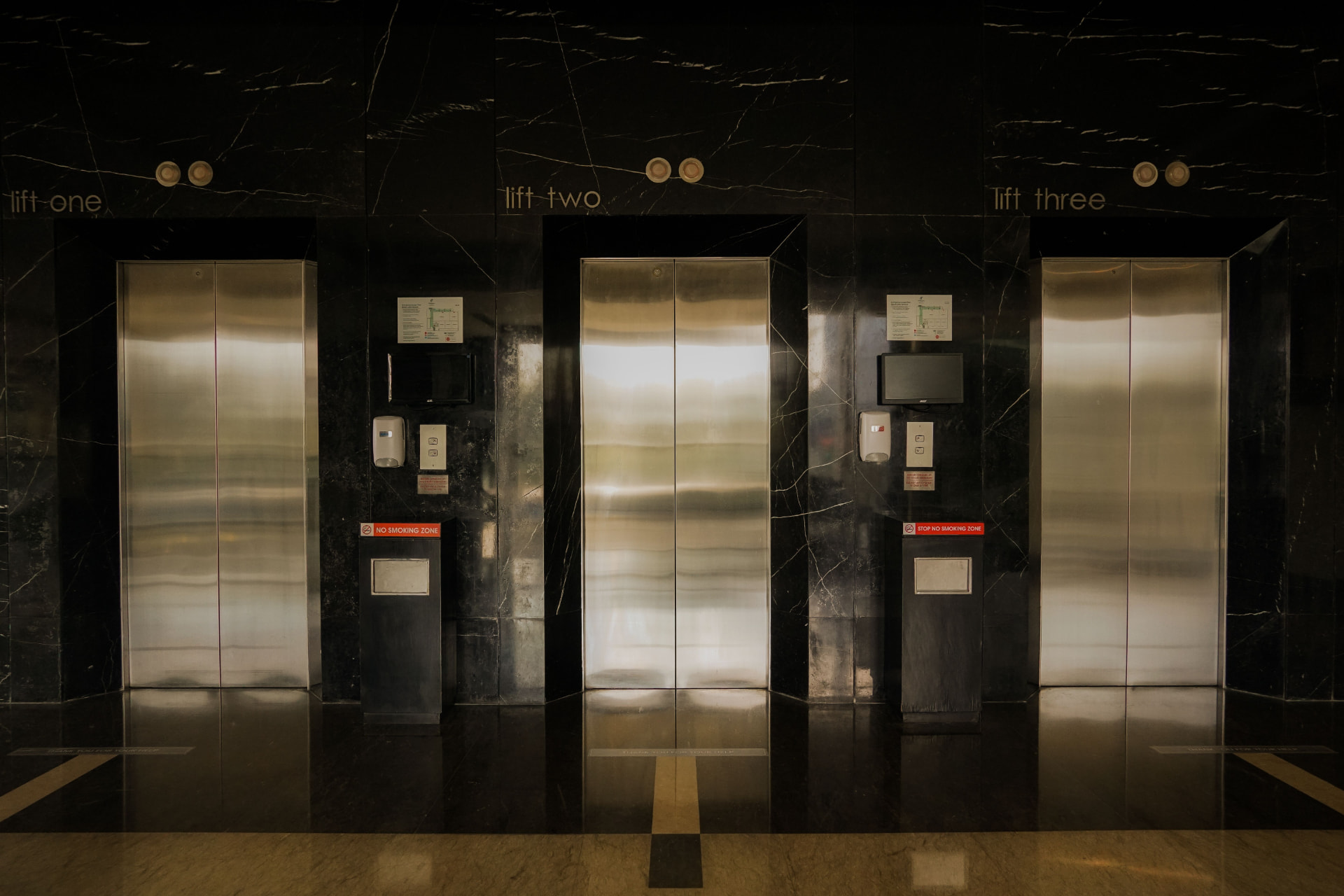 Marble lift lobby with three polished elevator doors